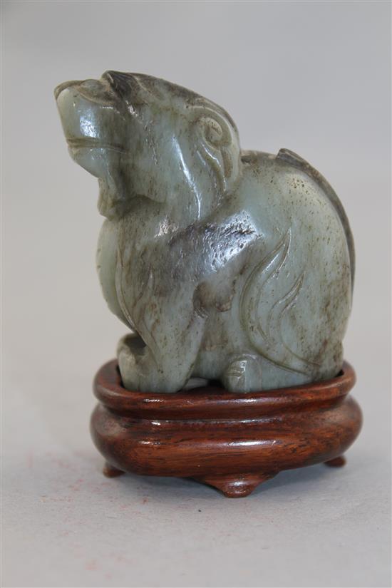 A Chinese pale grey and black jade carving of a lion-dog, Ming dynasty, 6cm., wood stand